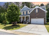 Beautiful two-story brick and siding home with a well-maintained lawn and attached garage at 1424 Forest Fern Ln, Fuquay Varina, NC 27526