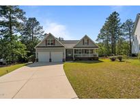 Charming home featuring a two-car garage, inviting front porch, and well-manicured lawn at 15 Clearwater Harbour Hbr, Sanford, NC 27332