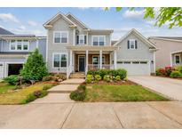 Charming two-story home with a well-manicured lawn and welcoming front porch at 1605 Silo Point Dr, Wake Forest, NC 27587
