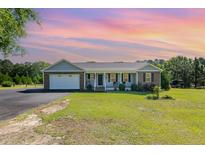 Charming one-story home featuring a manicured lawn, attached garage, and inviting front porch at 198 Fore View Ln, Sanford, NC 27332