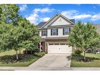 Charming two-story home featuring a brick-and-vinyl facade, landscaped yard, and a two-car garage at 2305 Everstone Rd, Wake Forest, NC 27587