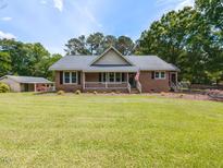 Charming one story brick home with a well manicured front lawn and a covered front porch at 235 Stephenson Rd, Benson, NC 27504