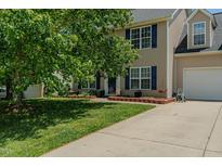 Charming two-story home featuring a well-manicured lawn, blue shutters, and an attached two car garage at 2412 Chartwell Ln, Graham, NC 27253