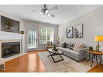 Bright living room with fireplace, ceiling fan, modern decor, and access to outdoor space at 3711 Ramblewood, Durham, NC 27713