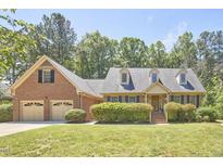 Charming brick home featuring a manicured lawn, dormer windows, and an attached two-car garage at 4420 Dula St, Durham, NC 27705