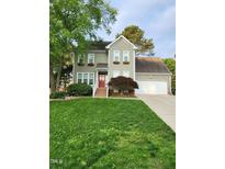 Charming two-story home with a well-manicured lawn and a welcoming red front door at 501 Samara St, Apex, NC 27502
