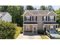 Charming two-story home with a well-manicured lawn, a covered front porch, and lovely curb appeal at 609 Woodson Dr, Clayton, NC 27527