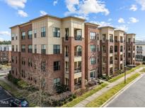 Attractive brick apartment building featuring balconies, light-colored accents, and well-maintained landscaping at 700 Finsbury St # 105, Durham, NC 27703