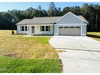 Charming single-story home featuring a two-car garage and inviting front yard at 71 Earnest Way, Kenly, NC 27542