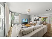 Bright, open-concept living room with a large sectional sofa and modern decor at 77 Rolling Creek Cir, Clayton, NC 27520
