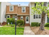 Charming townhome with brick and siding exterior and well-manicured landscaping in a vibrant community at 919 Lexington Ct, Cary, NC 27511