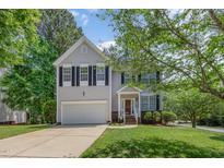 Charming two-story home with a well-manicured lawn and attached garage, complemented by mature trees at 100 Full Moon Ct, Garner, NC 27529