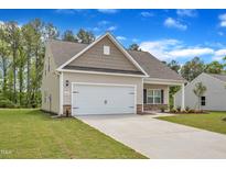 Charming home featuring stone accents, a two-car garage, and a well-manicured lawn at 1009 Rhino Bnd, Oxford, NC 27565
