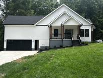 New construction with white siding, black trim, and a charming front porch at 101 Cochise Cv, Louisburg, NC 27549