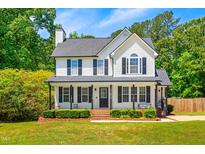 Charming two-story white home with black shutters, a brick walkway, and a beautifully landscaped front yard at 105 Kirkland Ct, Archer Lodge, NC 27527
