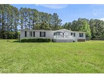 Charming one-story home with a white porch, complimented by a spacious lawn and bordered by trees at 109 Winding Creek Dr, Youngsville, NC 27596