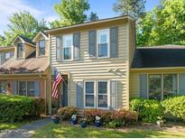 Charming two-story townhome with tan siding, gray shutters, and an American flag at 11 Stone Village, Durham, NC 27704