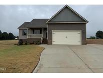 Charming home featuring a two-car garage, covered porch, and well-maintained lawn at 112 Royal Ave, Selma, NC 27576