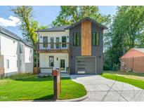 Striking two-story home with a modern design, mixed siding, a front-facing two-car garage, and a well-maintained lawn at 1124 Upchurch St, Raleigh, NC 27610