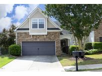 Charming home showcasing a stone facade, gray garage door, and manicured landscaping in a serene setting at 12306 Mossgreen St, Raleigh, NC 27614