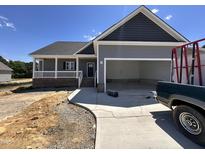 Charming single-story home featuring a covered porch, two-car garage, and fresh landscaping at 134 Royal Ave, Selma, NC 27576