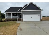 Charming single-Gathering home boasts a two-car garage, covered porch and low-maintenance landscaping at 134 Royal Ave, Selma, NC 27576