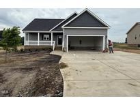 Charming home featuring a gray exterior, covered porch and a spacious two-car garage at 134 Royal Ave, Selma, NC 27576