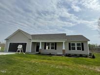 Charming single-story home with neutral siding, dark shutters and a two-car garage at 235 Starry Sky Dr, Benson, NC 27504