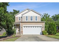 Charming two-story home with a well-maintained lawn and a two-car garage on a sunny day at 2523 Ferdinand Dr, Knightdale, NC 27545