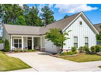 Charming home featuring light green siding, inviting front porch, and well-manicured landscaping at 2531 Impulsion Dr, New Hill, NC 27562