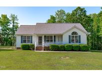 Charming single-story home featuring green shutters and manicured front yard shrubbery at 318 Duck Pond Ln, Clayton, NC 27520