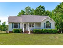 Charming single-story home with a cozy front porch and well-maintained landscaping at 318 Duck Pond Ln, Clayton, NC 27520