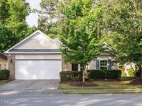 Charming single-Gathering home featuring a spacious two-car garage, manicured lawn, and mature trees at 33 Juliette Dr, Durham, NC 27713