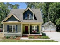 Charming home with a covered front porch, dark shutters, and a detached two-car garage at 3357 Denise St, Durham, NC 27704