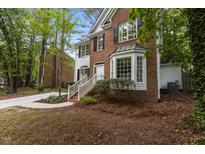 Charming brick and white home with lush landscaping and a welcoming front entrance at 3401 Scotch Dr, Raleigh, NC 27616
