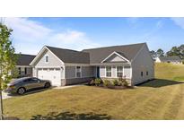 Charming single-story home featuring a two-car garage, stone accents, manicured lawn, and a welcoming blue front door at 36 High View Ct, Fuquay Varina, NC 27526