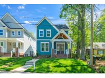Charming two-story blue home features a welcoming front porch and well-maintained lawn at 407 1/2 Carolina Ave, Raleigh, NC 27606