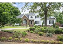 Charming two-story home featuring a blend of brick and white siding, complemented by a beautifully landscaped front yard at 4812 Cornoustie Ct, Holly Springs, NC 27540