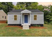 Charming single-story home featuring gray siding, a blue front door and a well-maintained lawn at 518 Avon Ave, Burlington, NC 27215