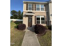 Charming brick front exterior featuring brown shutters and a covered entryway with the house number 523 at 523 Berry Chase Way, Cary, NC 27519