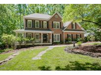 Charming brick home boasts a beautiful landscaped front yard and a welcoming porch at 5601 Jomali Dr, Durham, NC 27705