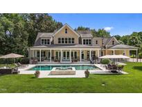 Stunning backyard with a large pool, outdoor seating, and a beautifully landscaped lawn for luxurious outdoor living at 60 Hartwood Ln, Youngsville, NC 27596