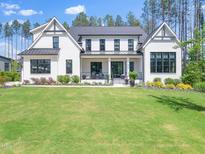 Stunning home with a manicured lawn, a classic painted brick facade, and elegant black trim accents at 604 Dappled Pine Ave, Durham, NC 27713