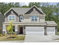 Charming two-story home with a three-car garage and stone accents, complemented by a well-maintained lawn at 605 Hampton Crest Ct, Fuquay Varina, NC 27526