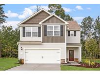 Charming two-story home with a two-car garage, manicured lawn and contrasting architectural features at 815 Rhino Bnd, Oxford, NC 27565