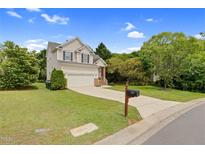 Charming two-story home with a well-maintained lawn, attached garage, and classic architectural details at 8820 Waynick Dr, Raleigh, NC 27617