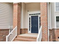 Inviting home entrance featuring a blue front door, brick columns, and crisp white trim at 8820 Waynick Dr, Raleigh, NC 27617
