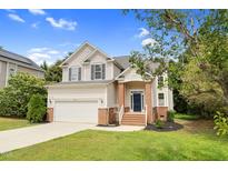 Charming two-story home with a well-manicured lawn, attached garage, and inviting front porch at 8820 Waynick Dr, Raleigh, NC 27617