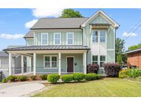 Charming two-story home with a covered porch and manicured landscaping at 905 E Lenoir St, Raleigh, NC 27610