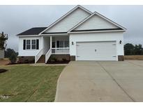 Charming, newly built one-story home with a white exterior, black shutters, and a two-car garage at 94 Royal Ave, Selma, NC 27576